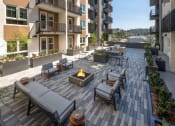 Thumbnail 35 of 48 - an outdoor patio with a firepit and lounge chairs at VORA LUX, San Diego