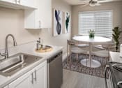 Thumbnail 2 of 33 - Kitchen and dining space for a circular table with chairs at Canyon Park Apartments, Beaverton, OR 97005