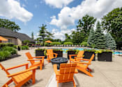 Thumbnail 16 of 19 - an outdoor patio with orange chairs and a fire pit and a pool