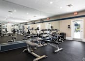 Thumbnail 18 of 24 - A gym with a variety of equipment including treadmills, weights, and exercise machines.