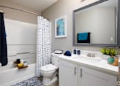 Thumbnail 10 of 24 - A bathroom with a toilet, sink, and shower.