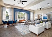 Thumbnail 14 of 24 - A living room with a blue chair and a white sofa.