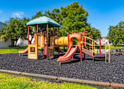 Thumbnail 23 of 24 - A playground with a red and yellow slide and a green roofed structure.