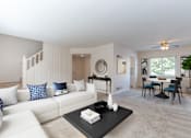 Thumbnail 3 of 55 - A living room with a white couch and a black coffee table.