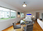 Thumbnail 23 of 55 - A modern living room with a glass dining table and chairs.
