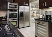 Thumbnail 35 of 41 - A modern kitchen with a stainless steel refrigerator and oven.