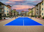 Thumbnail 26 of 34 - a pickleball court in the middle of an apartment complex