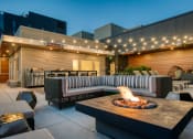 Thumbnail 13 of 30 - a patio with a fire pit and seating around it