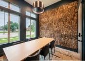 Thumbnail 7 of 28 - a conference room with a long wooden table and chairs and a wall of logs