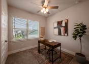 Thumbnail 14 of 28 - an office with a large window and a ceiling fan
