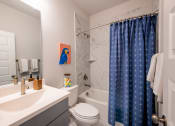 Thumbnail 16 of 28 - a bathroom with a shower and a sink and a toilet
