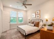 Thumbnail 12 of 28 - a bedroom with a bed and a ceiling fan