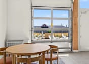 Thumbnail 22 of 22 - A room with a table and chairs in front of a large window.