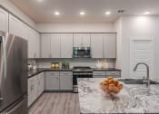 Thumbnail 3 of 31 - a kitchen with stainless steel appliances and marble counter tops