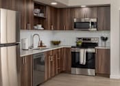 Thumbnail 1 of 34 - A modern kitchen with wooden cabinets and stainless steel appliances.