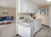 Thumbnail 5 of 29 - Kitchen with white cabinets and a sink and a living room with a couch at Summerfield, Tigard, OR