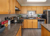 Thumbnail 2 of 28 - a kitchen with wooden cabinets and stainless steel appliances