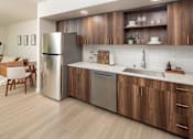 Thumbnail 10 of 34 - A modern kitchen with wooden cabinets and stainless steel appliances.