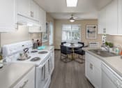 Thumbnail 1 of 29 - Kitchen with white appliances and a dining room with a table and chairs at Summerfield, OR, 97224