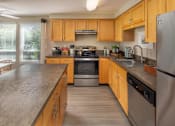 Thumbnail 1 of 28 - a kitchen with wooden cabinets and stainless steel appliances