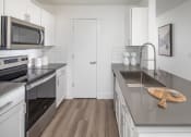 Thumbnail 10 of 38 - Modern kitchen with stainless steel appliances and gray counter tops at Arbor Heights, Tigard