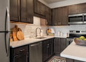 Thumbnail 4 of 35 - A kitchen with black cabinets and a white countertop.