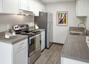 Thumbnail 1 of 28 - A modern kitchen with a stove, refrigerator, and sink.