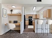 Thumbnail 2 of 36 - A kitchen with a desk and chair in the foreground.