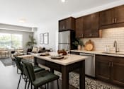 Thumbnail 6 of 35 - A modern kitchen with dark brown cabinets and a white countertop.