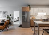 Thumbnail 59 of 68 - A modern kitchen with a refrigerator, sink, and dining table.