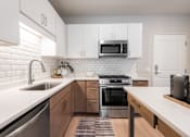 Thumbnail 68 of 68 - A modern kitchen with a stainless steel oven and white subway tiles.