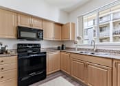 Thumbnail 1 of 36 - A kitchen with wooden cabinets and black appliances.