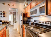 Thumbnail 3 of 18 - a kitchen with wood cabinets and stainless steel appliances