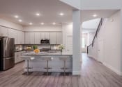 Thumbnail 5 of 31 - an open kitchen with a large island with three bar stools