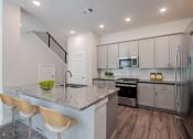 Thumbnail 19 of 31 - a kitchen with a marble counter top and stainless steel appliances