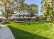 Thumbnail 5 of 15 - a yard with grass and trees in front of a house