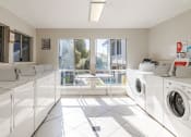 Thumbnail 10 of 15 - a washer and dryer room with washing machines and a window