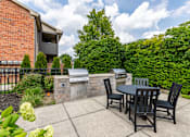 Thumbnail 16 of 19 - A patio with a table and chairs is set up outside a house.