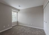 Thumbnail 10 of 19 - A room with a carpeted floor and a window with blinds.