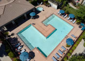 Thumbnail 17 of 22 - overhead drone shot of exterior pool surrounded by lounge chairs and umbrellas 