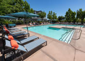 Thumbnail 15 of 22 - expansive pool with surrounding lounge chairs and umbrellas