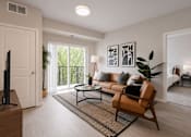 Thumbnail 66 of 68 - A living room with a brown leather chair and a coffee table.