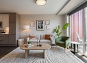 Thumbnail 5 of 34 - A modern living room with a green armchair and a grey sofa.
