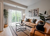 Thumbnail 67 of 68 - A living room with a brown leather chair and a glass coffee table.