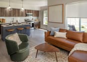 Thumbnail 5 of 34 - A modern living room with a green armchair and a brown leather couch.