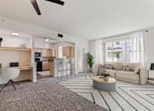Thumbnail 3 of 36 - A modern living room with a grey carpet and a white ceiling fan.