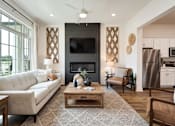 Thumbnail 3 of 27 - A modern living room with a fireplace and a television.