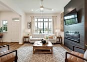 Thumbnail 23 of 27 - A modern living room with a brown rug and a white sofa.