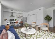 Thumbnail 16 of 30 - a living room with a blue couch and a green and white rug