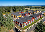 Thumbnail 33 of 34 - A large building complex with red and yellow buildings surrounded by trees.